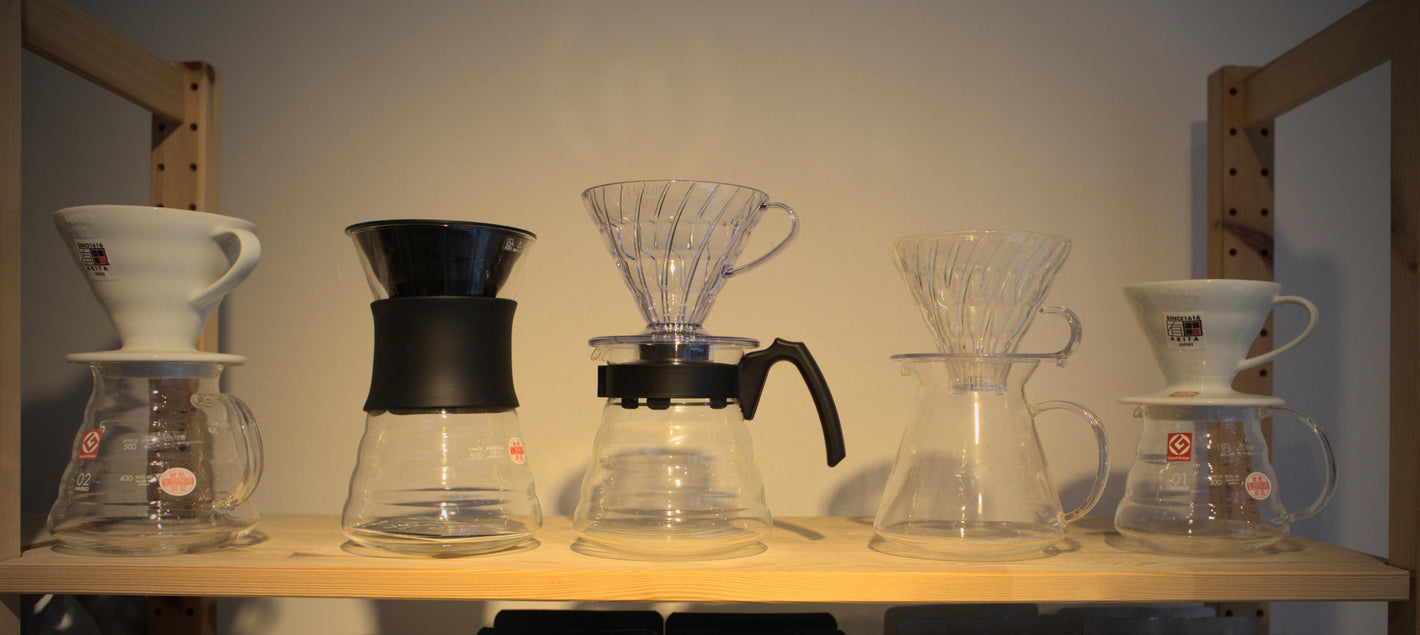Ein Regal mit 5 Pour-over-Filterhaltern und zugehörigen Kaffee-Karaffen 