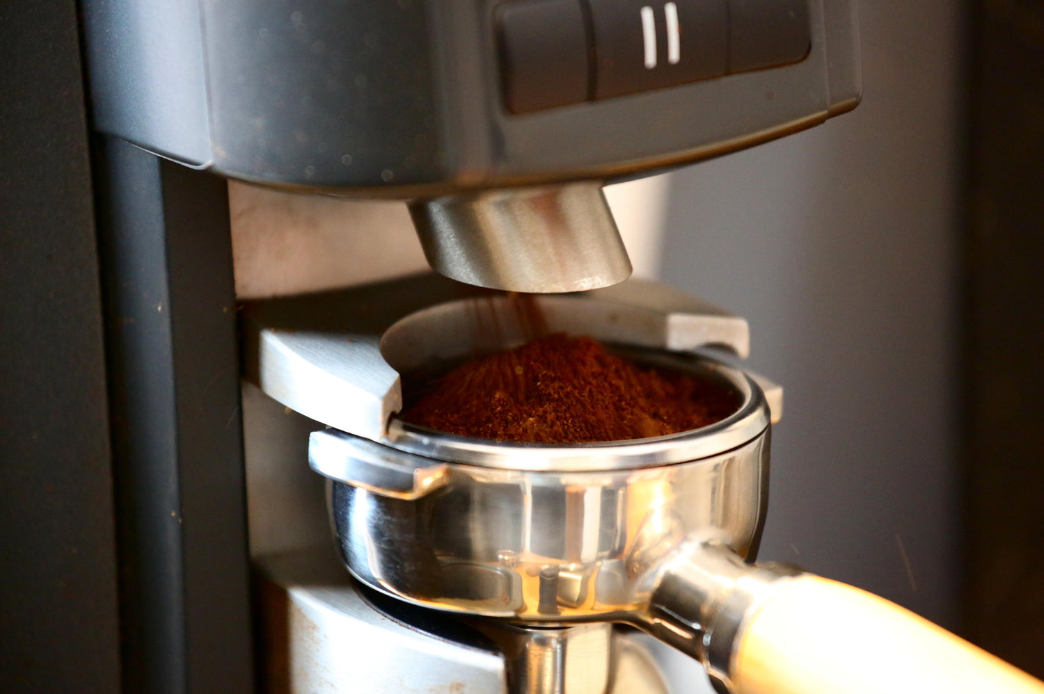 Kaffee, der frisch aus einer Rancilio-Mühle in einen Siebträger gemahlen wird